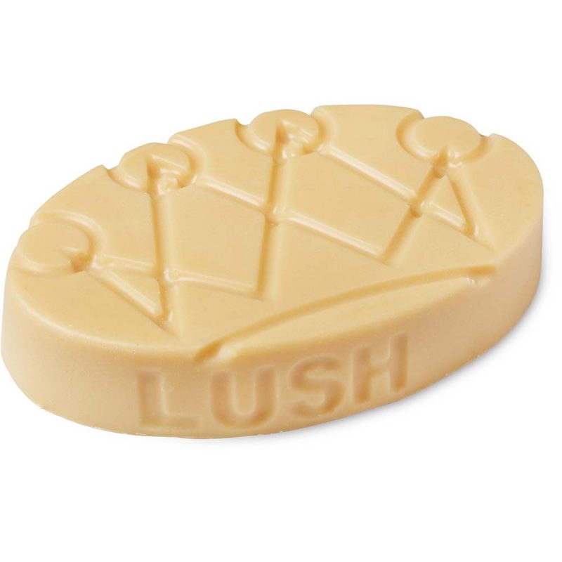 Lord of Misrule. A cream oval shaped, solid massage bar, with a crown design on top, and the Lush logo moulded along the edge.