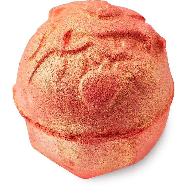 Partridge In A Pear Tree, a red-orange, round bath bomb with an ornate floral and bird design, dusted with golden lustre.